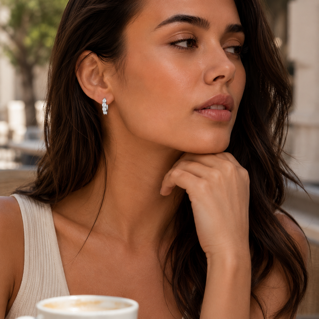 Woman with a cup of coffee, wearing earrings, in an outdoor setting