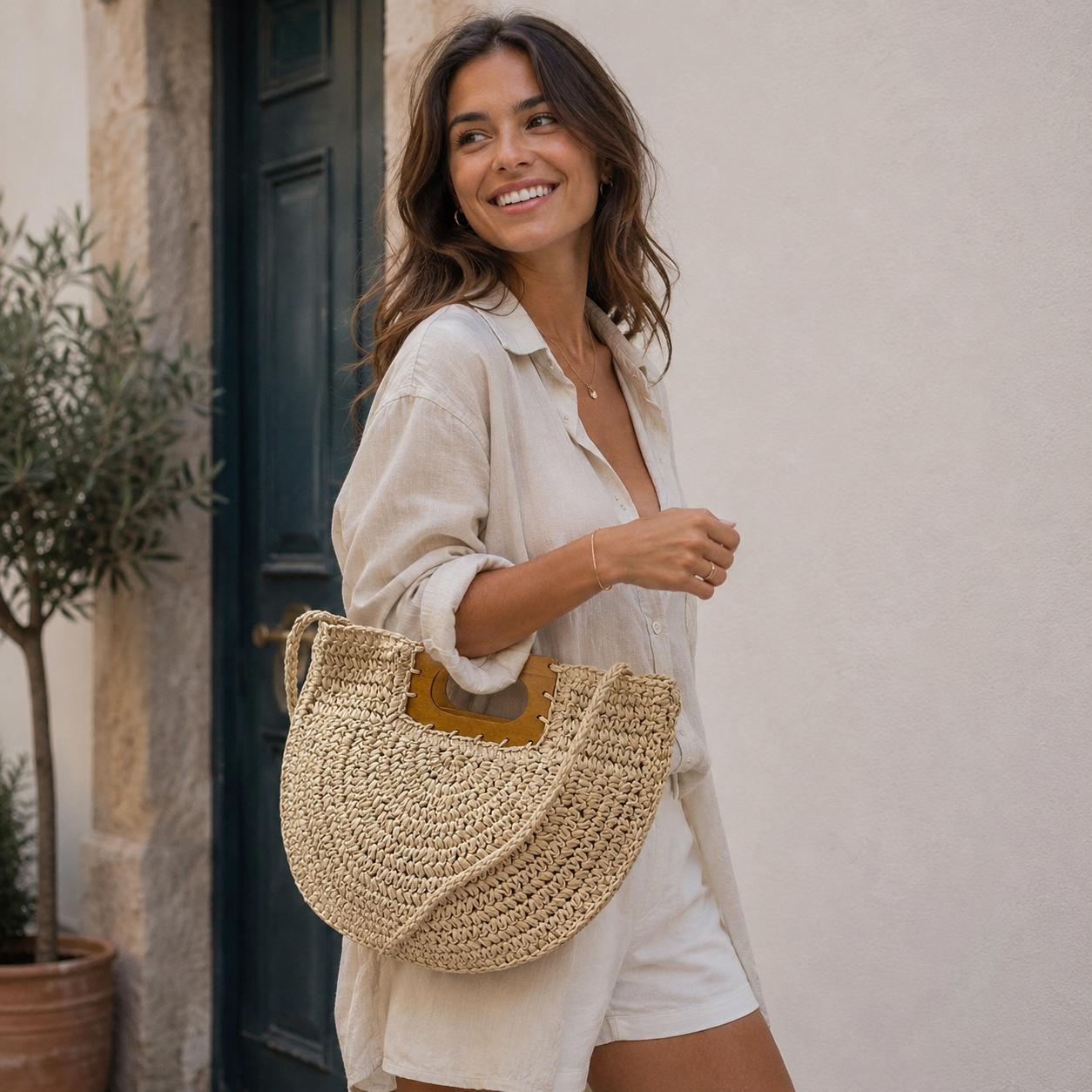 Woman holding a woven bag in front of a building