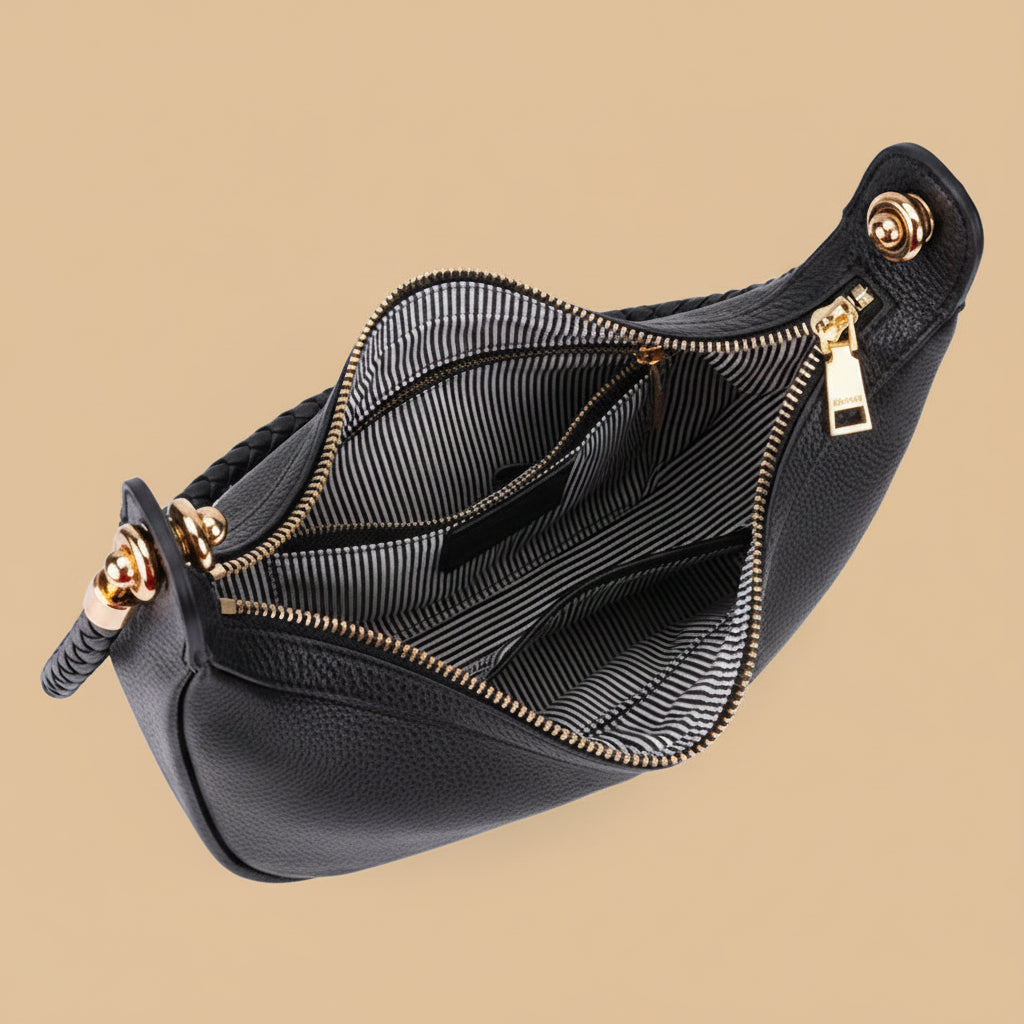 Black pebbled leather clutch bag shown open to display the interior, featuring a black and white striped lining, gold-tone zippers, and a braided leather strap, set against a solid beige background.